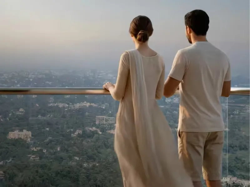 Couple on a terrace-style balcony overlooking the greens